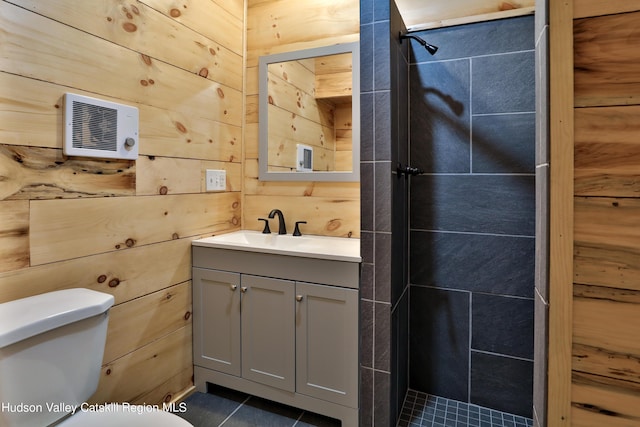 bathroom with a shower, vanity, toilet, and wooden walls