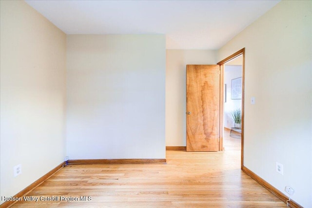 spare room featuring wood finished floors and baseboards