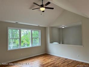 unfurnished room featuring ceiling fan, lofted ceiling, and light wood-type flooring