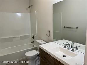 full bathroom featuring vanity, bathtub / shower combination, and toilet