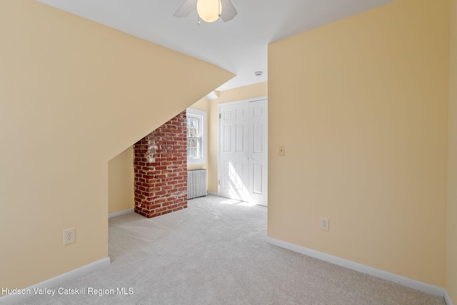 interior space featuring carpet flooring, ceiling fan, radiator, and baseboards