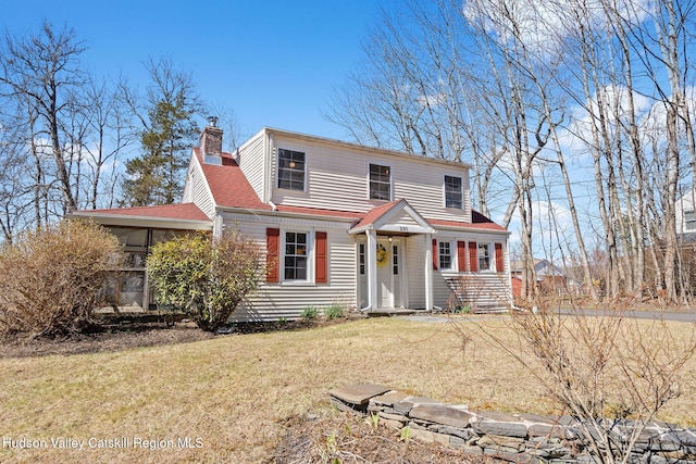 view of front of property with a shingled roof, a chimney, and a front lawn