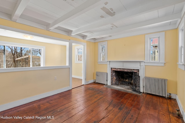 unfurnished living room featuring beam ceiling, radiator heating unit, baseboards, and a fireplace
