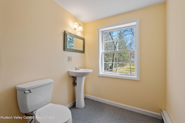 bathroom with toilet, a baseboard radiator, baseboards, and a sink