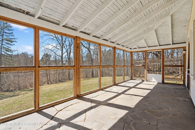 unfurnished sunroom featuring beam ceiling