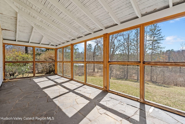 unfurnished sunroom with beamed ceiling
