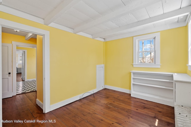 empty room with beam ceiling, baseboards, wood-type flooring, and wood ceiling