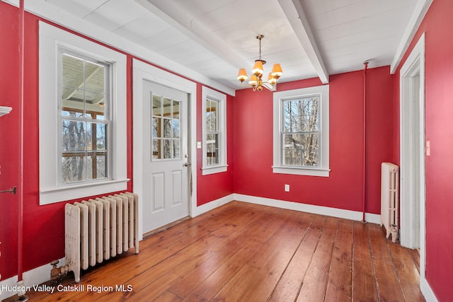 entrance foyer with a chandelier, radiator, beamed ceiling, and hardwood / wood-style flooring