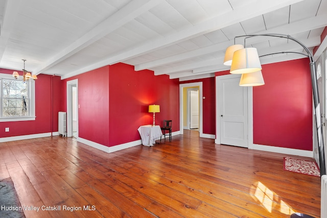 unfurnished living room featuring wood-type flooring, baseboards, beam ceiling, and a notable chandelier