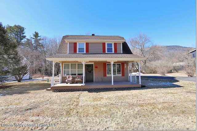 view of front of property with a porch, a front lawn, and a shingled roof