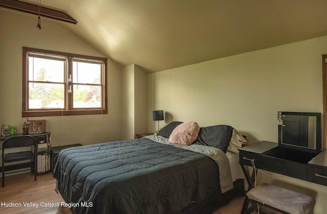 bedroom with light hardwood / wood-style floors and lofted ceiling