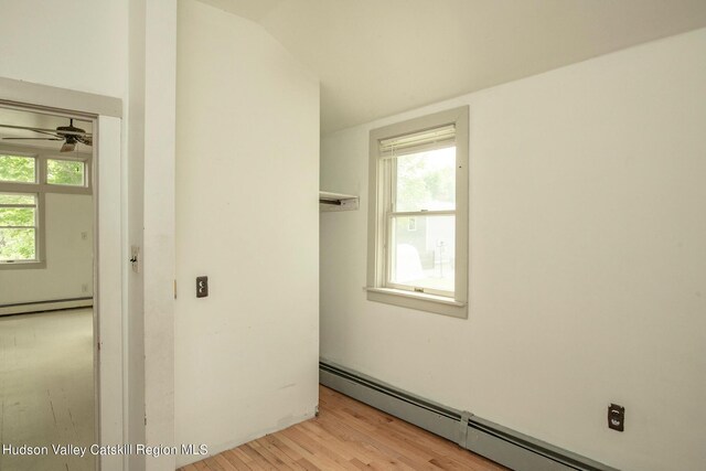 empty room featuring plenty of natural light, light hardwood / wood-style flooring, and a baseboard radiator