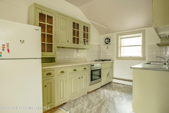 kitchen featuring sink, oven, white fridge, and cream cabinetry