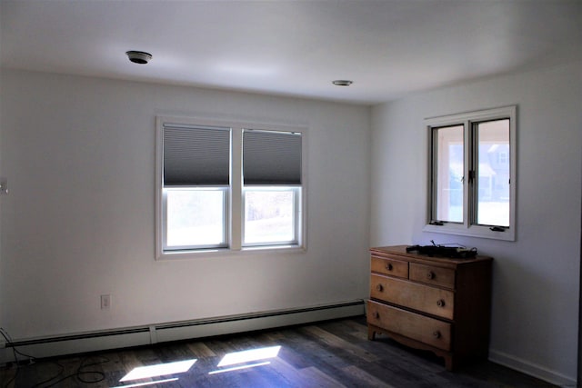 unfurnished room with dark hardwood / wood-style floors and baseboard heating