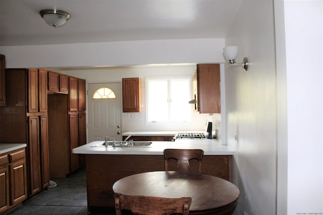 kitchen featuring a breakfast bar, extractor fan, dark tile patterned floors, sink, and range