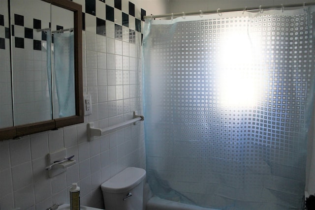 bathroom featuring shower / bathtub combination with curtain, tile walls, and toilet