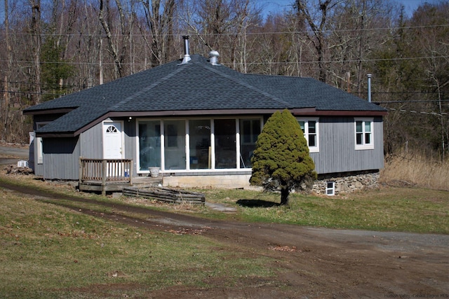 rear view of house featuring a sunroom and a yard