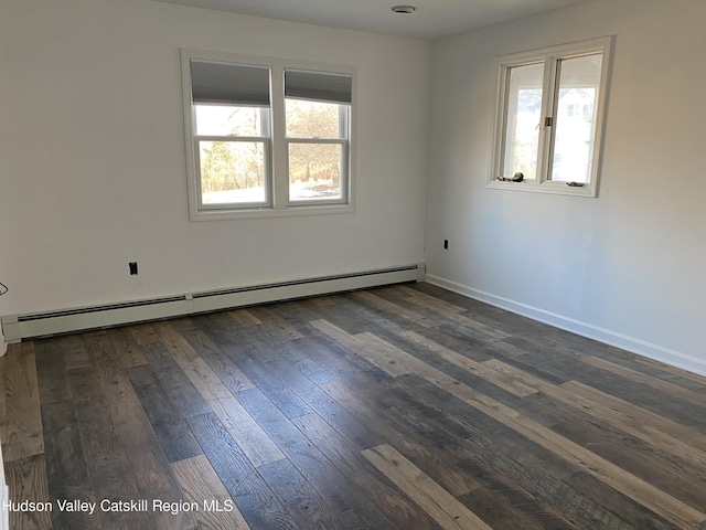 spare room featuring a baseboard radiator and dark hardwood / wood-style floors