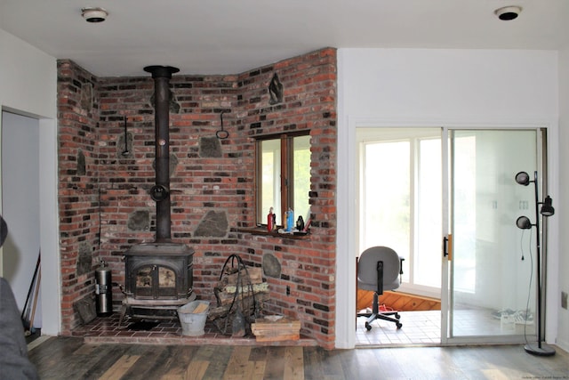 living room with hardwood / wood-style floors, a healthy amount of sunlight, and a wood stove