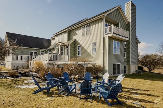 27 Gallagher Ln, Pleasant Valley, NY 12569 - back of property with an outdoor fire pit, a chimney, a wooden deck, and a lawn