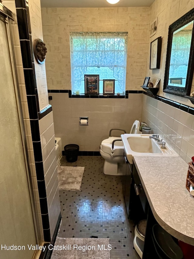 24 Linden Ave, Red Hook, NY 12571 - full bathroom featuring tile walls, vanity, a shower with shower door, and wainscoting
