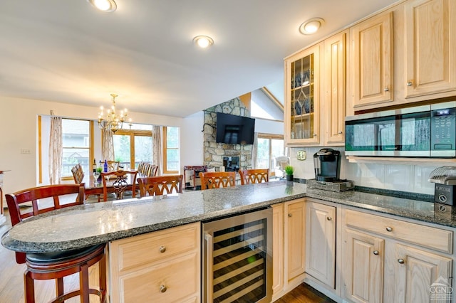108 Botti Dr, Hunter, NY 12442 - kitchen with wine cooler, stainless steel microwave, a peninsula, a kitchen breakfast bar, and light brown cabinetry