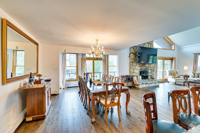108 Botti Dr, Hunter, NY 12442 - dining space with a baseboard radiator, a chandelier, a stone fireplace, dark wood-type flooring, and vaulted ceiling