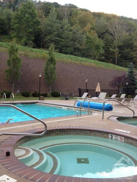 64 Liftside Dr Unit E-5, Hunter, NY 12442 - community pool with fence, a forest view, a community hot tub, and a patio