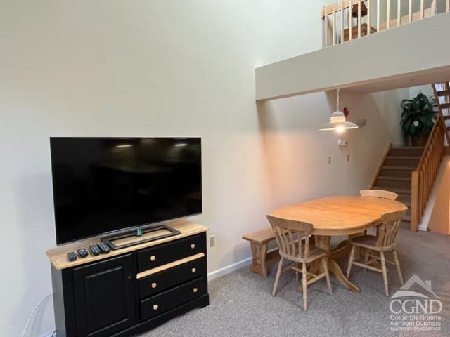 64 Liftside Dr Unit E-5, Hunter, NY 12442 - dining area with stairs, carpet, a towering ceiling, and baseboards