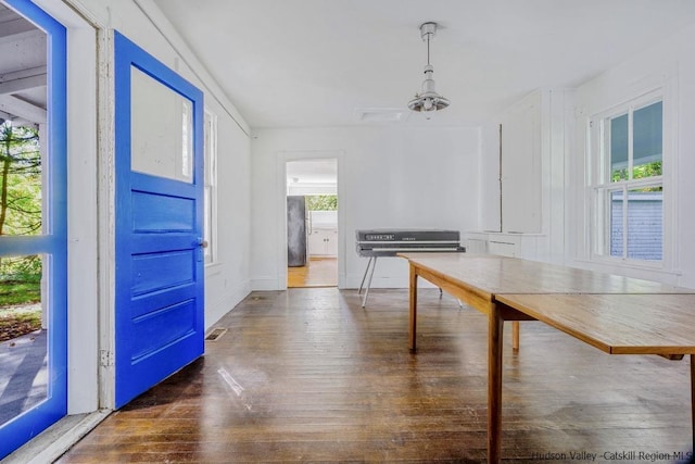 unfurnished dining area with dark wood-type flooring