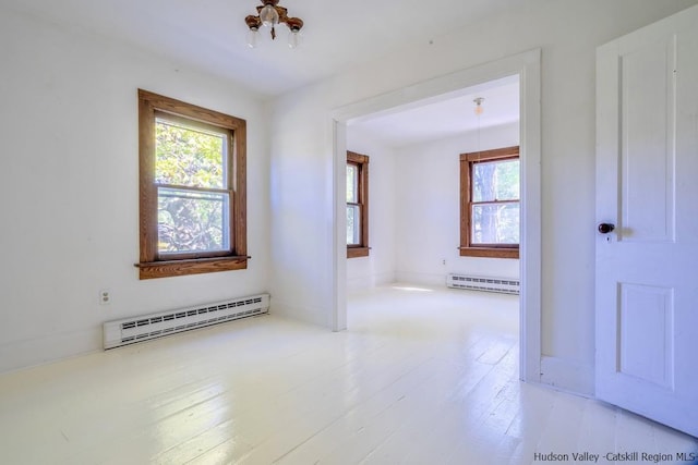 spare room with plenty of natural light, light hardwood / wood-style flooring, and a baseboard heating unit