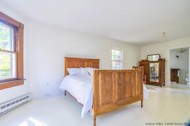 bedroom featuring ensuite bathroom, multiple windows, and a baseboard radiator