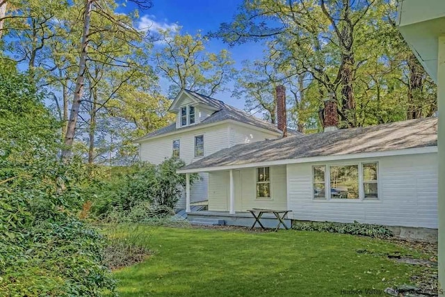 rear view of property featuring a yard