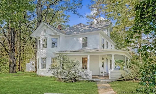 view of front of house with covered porch and a front lawn