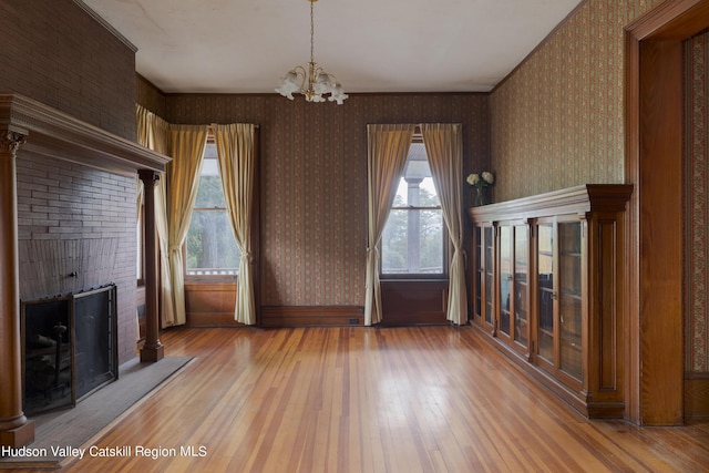 unfurnished dining area with a notable chandelier and hardwood / wood-style flooring