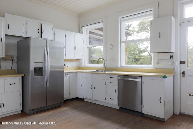 kitchen with plenty of natural light, white cabinets, dark wood-type flooring, and appliances with stainless steel finishes