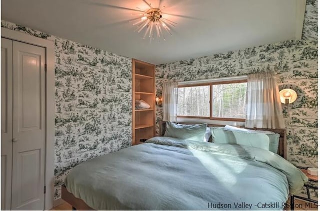 bedroom with a ceiling fan and wallpapered walls