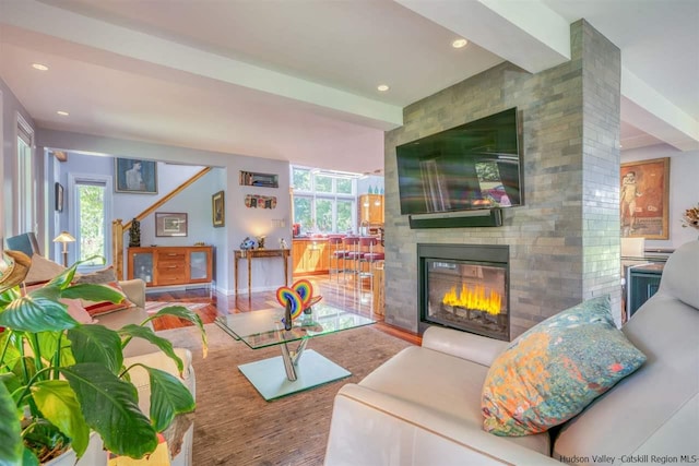 living area featuring a large fireplace, recessed lighting, and wood finished floors