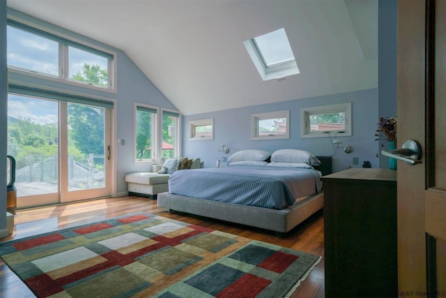 bedroom featuring a skylight, high vaulted ceiling, access to outside, and wood finished floors