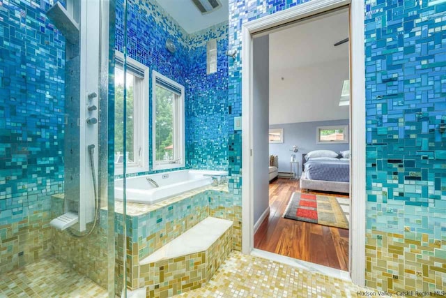 bathroom with a garden tub, ensuite bath, and tiled shower