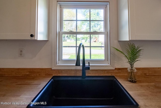 interior details featuring white cabinetry and sink