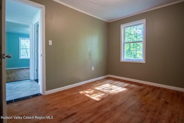 spare room with hardwood / wood-style flooring and crown molding