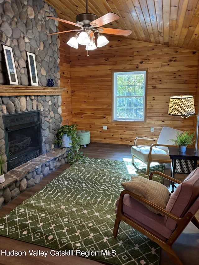 living room with wooden walls, vaulted ceiling, and wooden ceiling