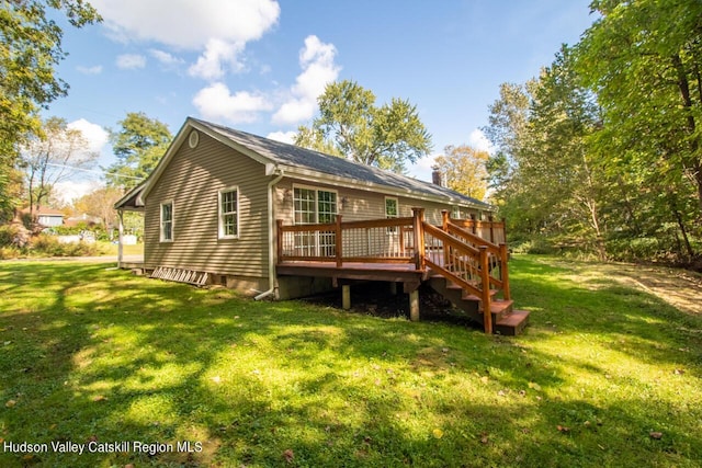 rear view of house with a lawn and a wooden deck