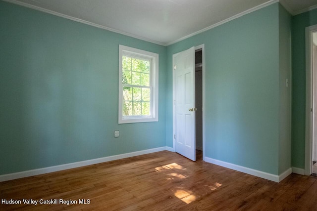 unfurnished bedroom featuring hardwood / wood-style floors and crown molding