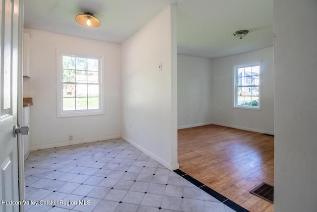 empty room with light wood-type flooring and plenty of natural light