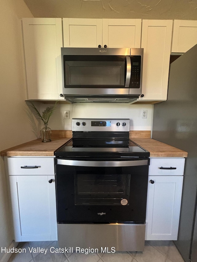 kitchen featuring butcher block countertops, white cabinetry, and appliances with stainless steel finishes