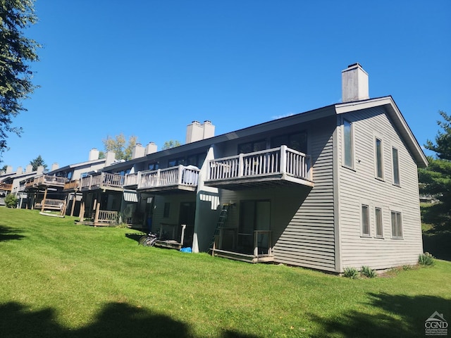 76 Loo Bridge Ln Unit 12B, Windham, NY 12496 - back of house featuring a chimney, a lawn, and a balcony