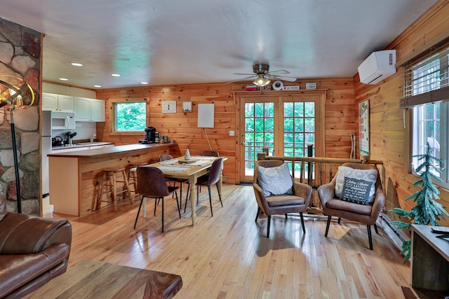 dining space featuring a wall mounted air conditioner, wood walls, a ceiling fan, light wood-style flooring, and recessed lighting