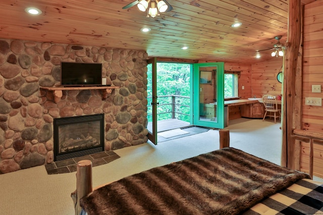 carpeted bedroom with access to exterior, recessed lighting, wooden ceiling, and a stone fireplace